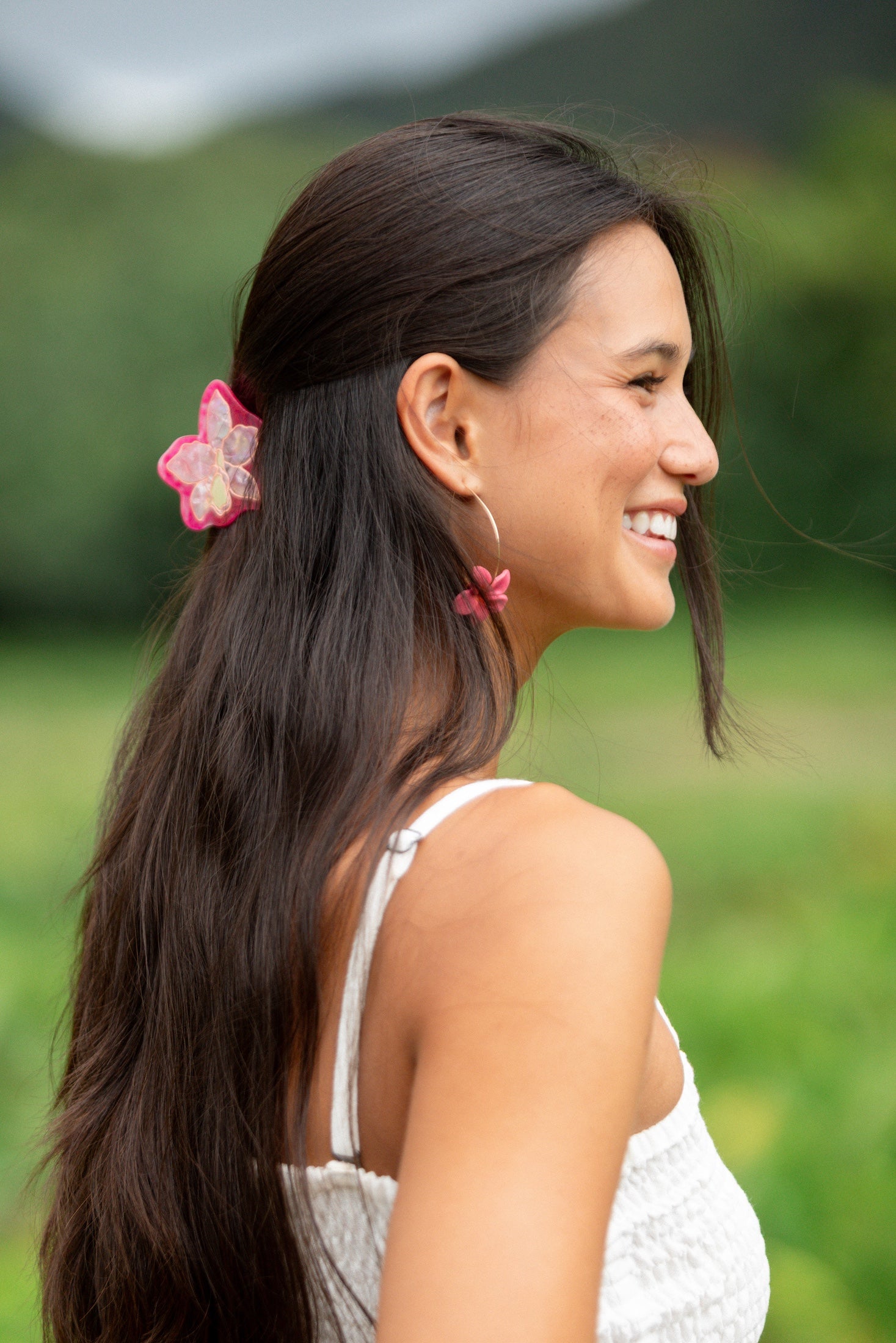 woman wearing a small pink and peach orchid hairclip in hair 