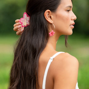 woman wearing a small pink and peach orchid hairclip in hair 