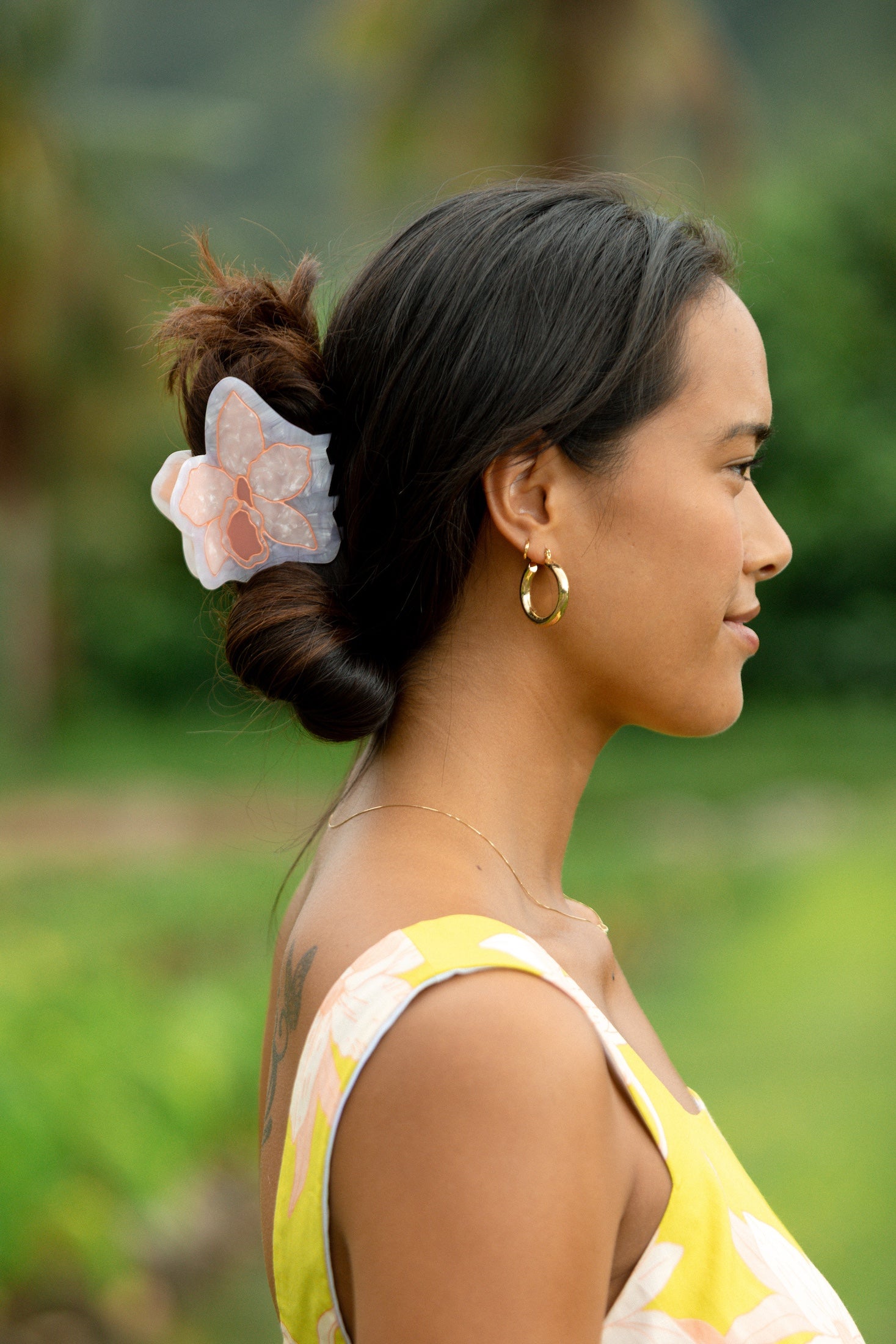 woman wearing a large peach and white orchid hair clip in hair