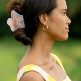 woman wearing a large peach and white orchid hair clip in hair