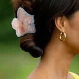 woman wearing a large peach and white orchid hair clip in hair