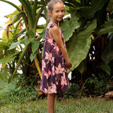 little girl wearing dark purple dress with flutter sleeve and orchid print