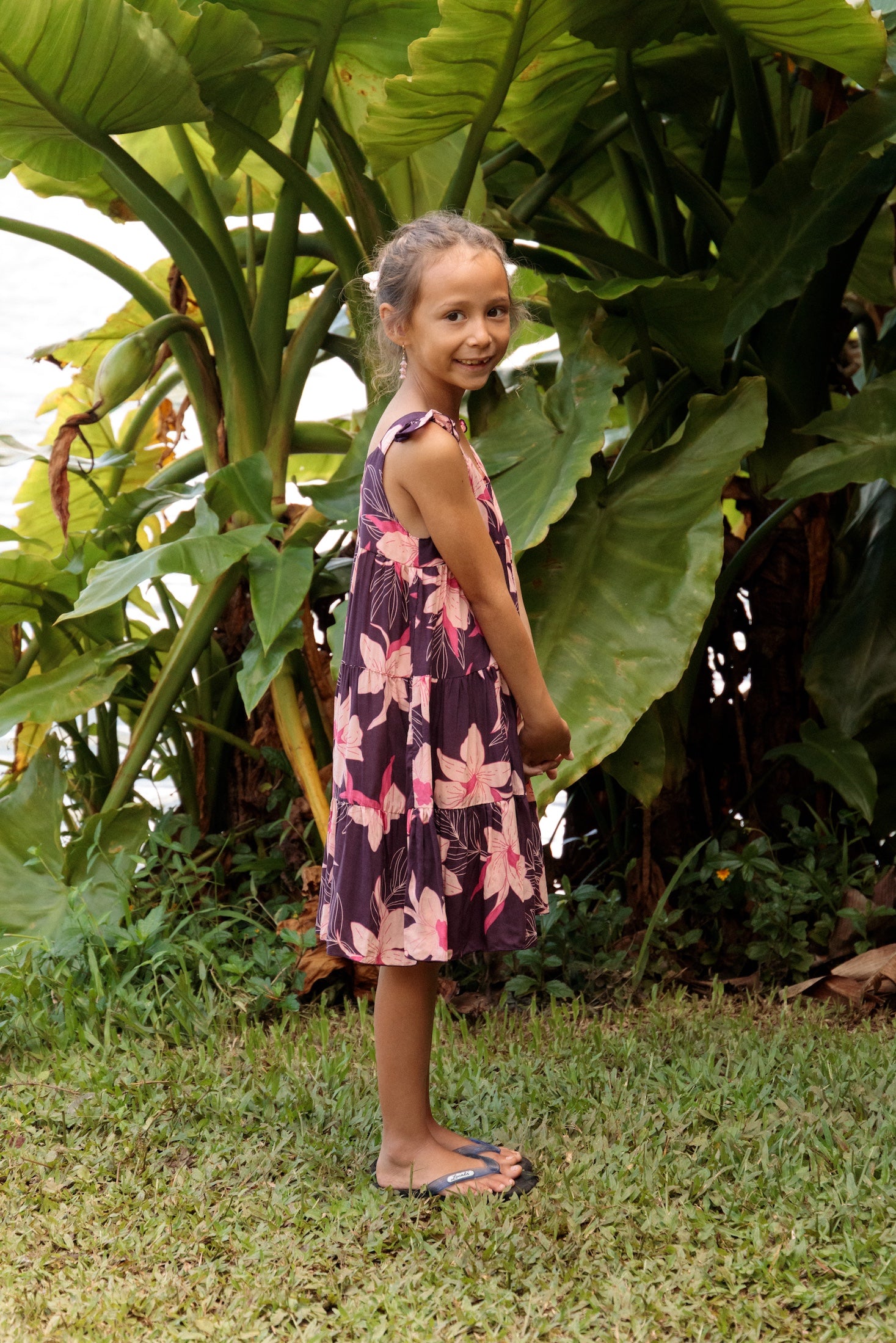 little girl wearing dark purple dress with flutter sleeve and orchid print