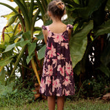 little girl wearing dark purple dress with flutter sleeve and orchid print