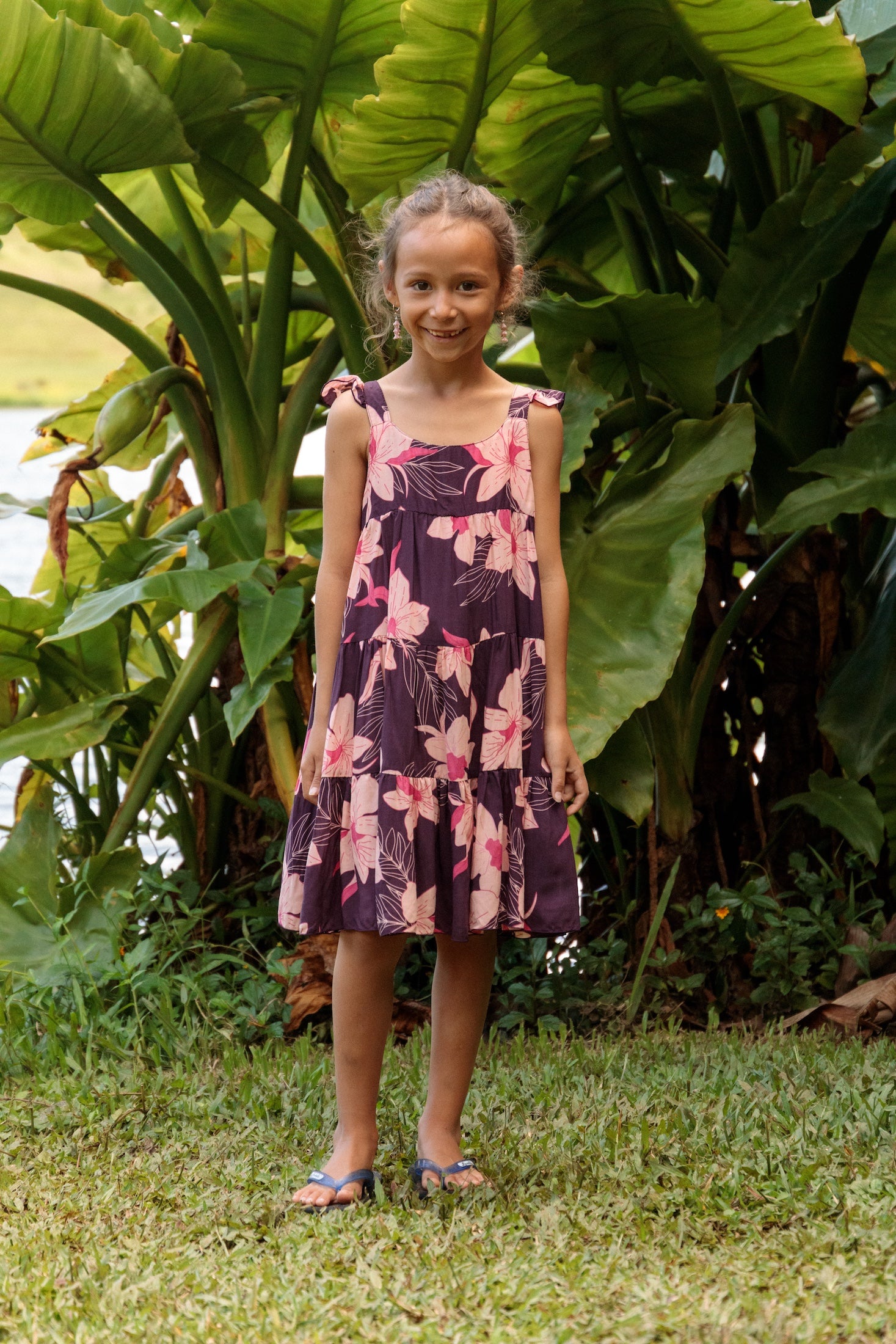 little girl wearing dark purple dress with flutter sleeve and orchid print