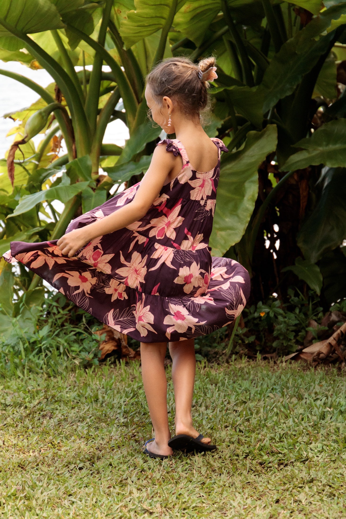 little girl wearing dark purple dress with flutter sleeve and orchid print