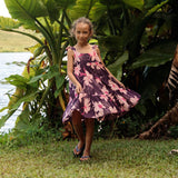 little girl wearing dark purple dress with flutter sleeve and orchid print