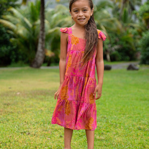 little girl wearing a long pink tiered dress with ruffle straps