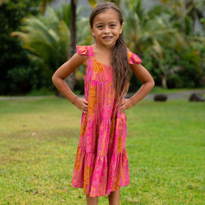 little girl wearing a long pink tiered dress with ruffle straps