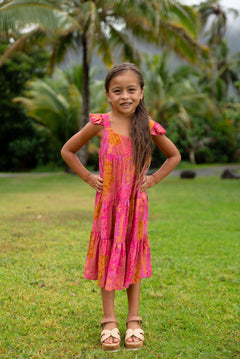 little girl wearing a long pink tiered dress with ruffle straps
