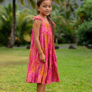 little girl wearing a long pink tiered dress with ruffle straps