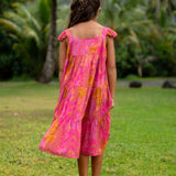 little girl wearing a long pink tiered dress with ruffle straps