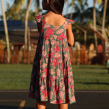 little girl wearing a teal dress with flutter sleeves with shell and pua print