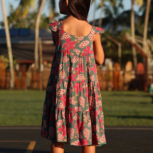 little girl wearing a teal dress with flutter sleeves with shell and pua print