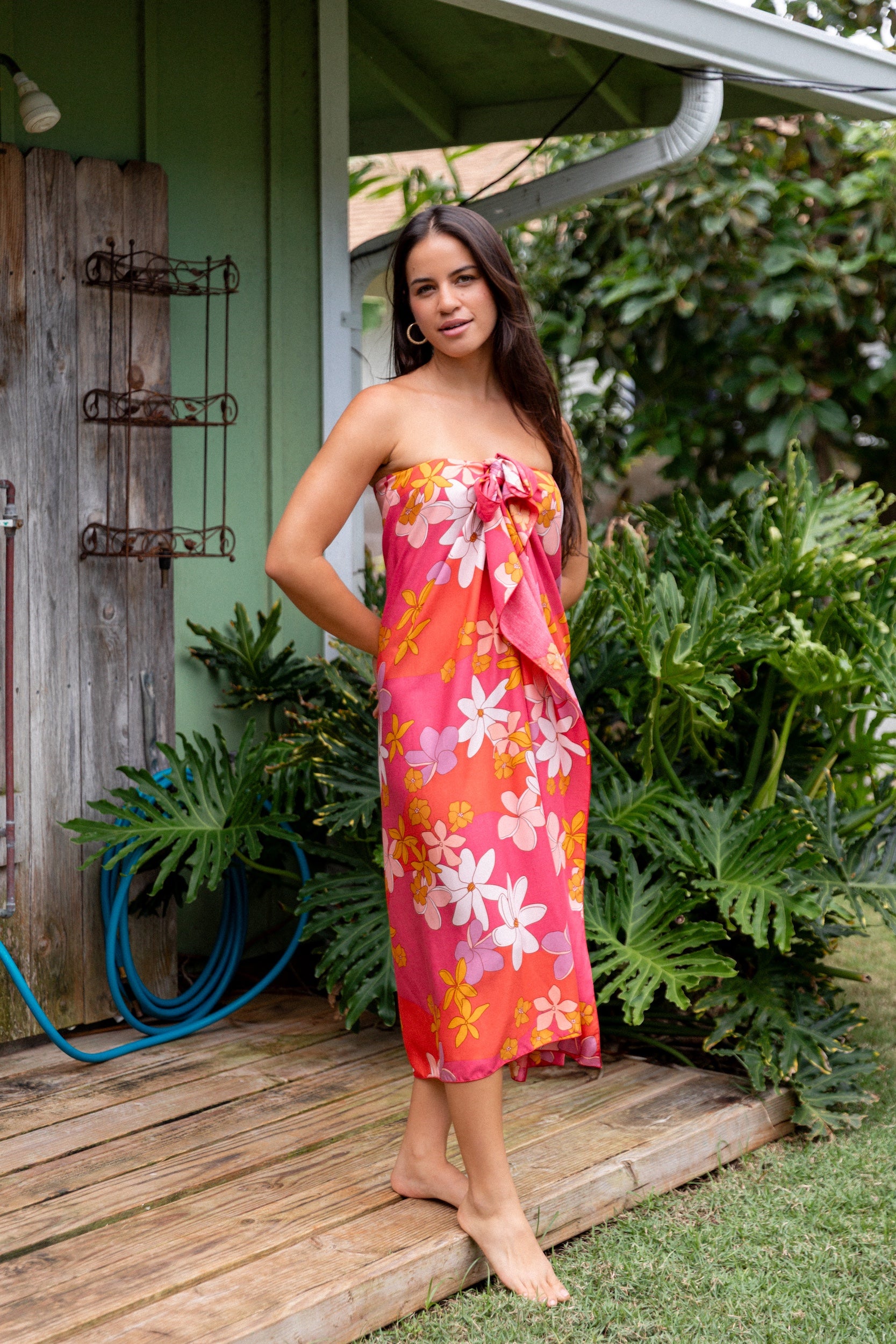 woman with brown hair wearing bright pink pareo with flower retro flower print