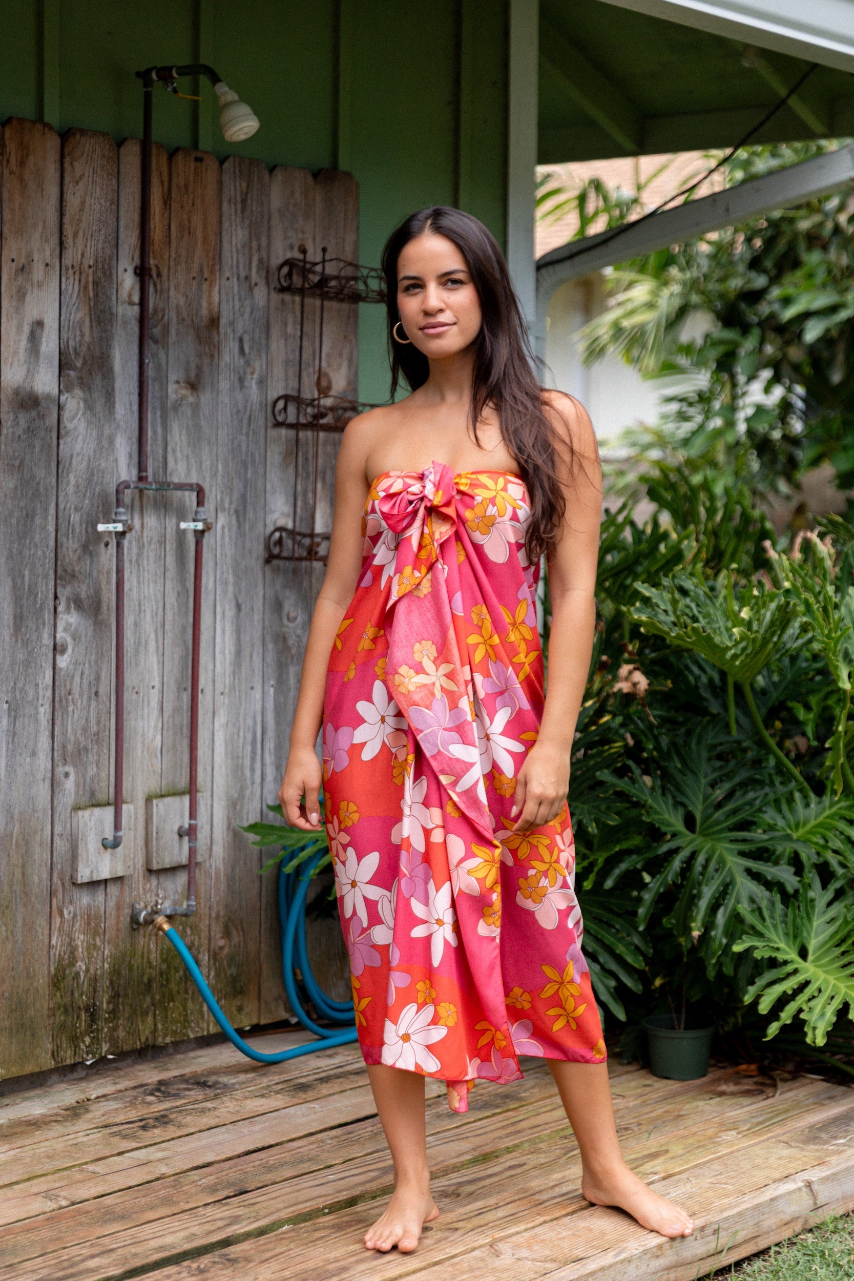 woman with brown hair wearing bright pink pareo with flower retro flower print