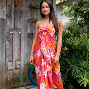 woman with brown hair wearing bright pink pareo with flower retro flower print