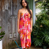 woman with brown hair wearing bright pink pareo with flower retro flower print