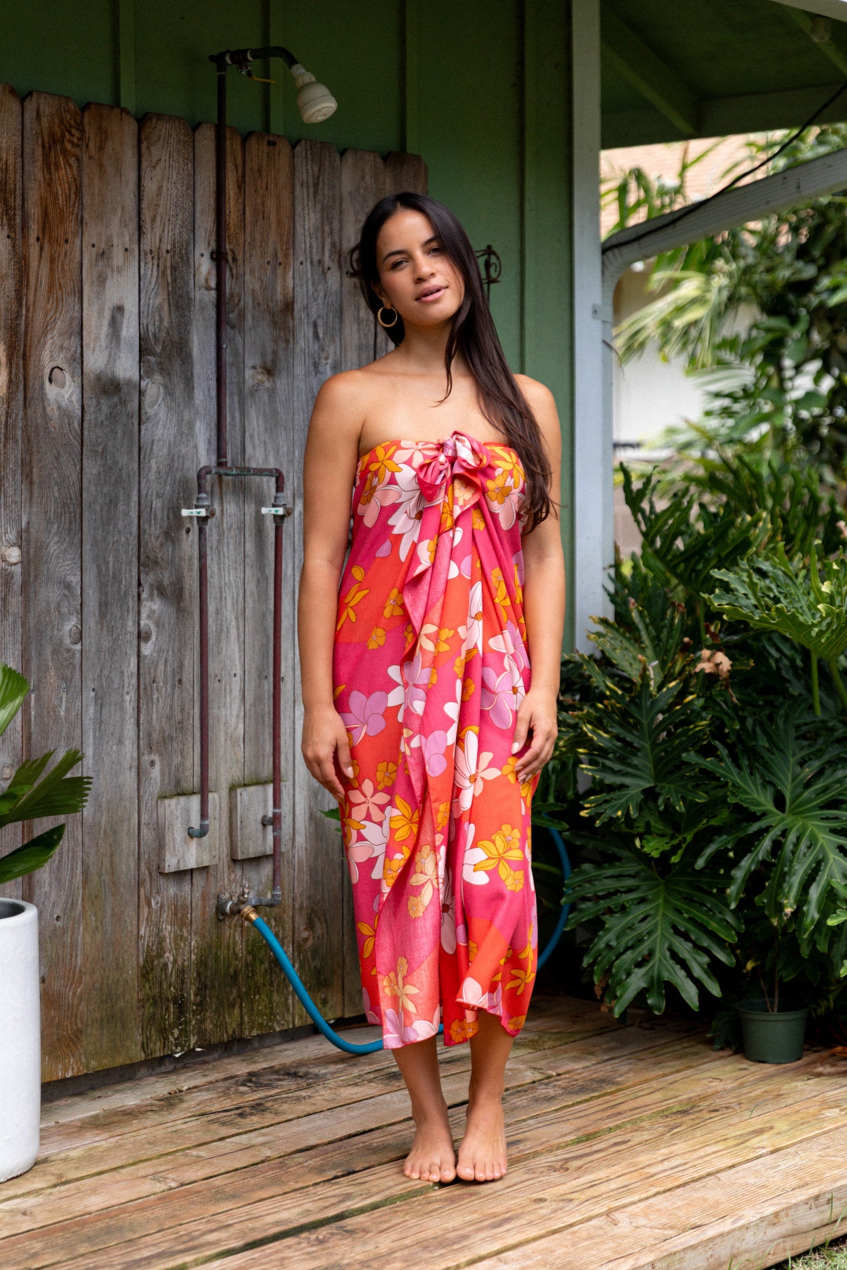 woman with brown hair wearing bright pink pareo with flower retro flower print