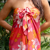 woman with brown hair wearing bright pink pareo with flower retro flower print