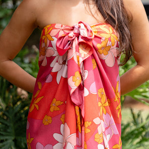woman with brown hair wearing bright pink pareo with flower retro flower print