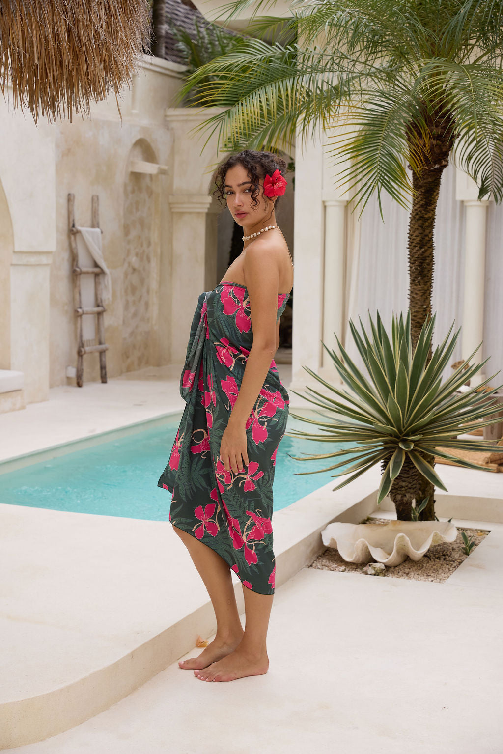woman with brown hair wearing dark green pareo with fern and ginger print 