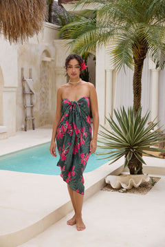 woman with brown hair wearing dark green pareo with fern and ginger print 