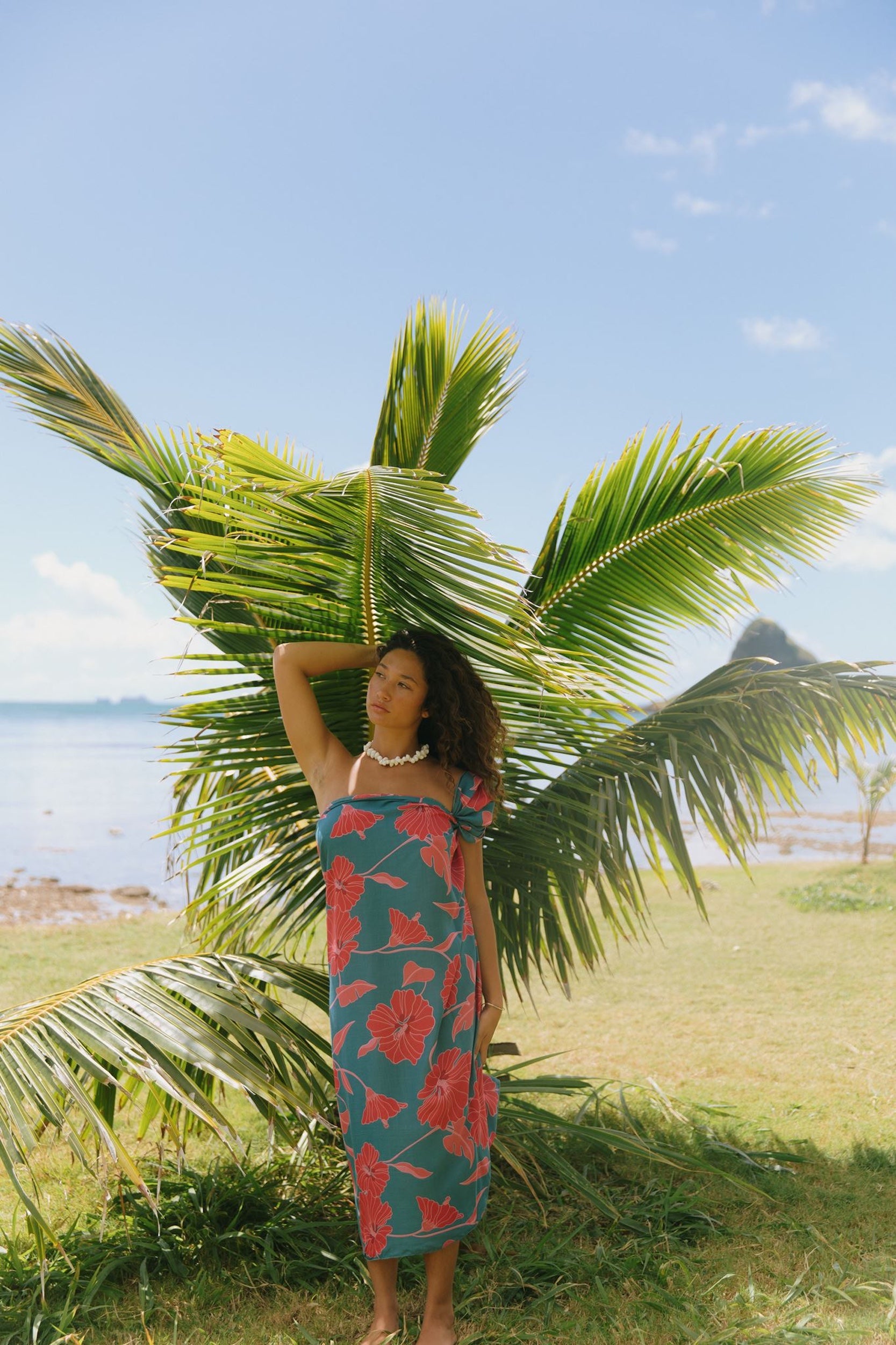 woman wearing rich teal pareo with red hau flower print