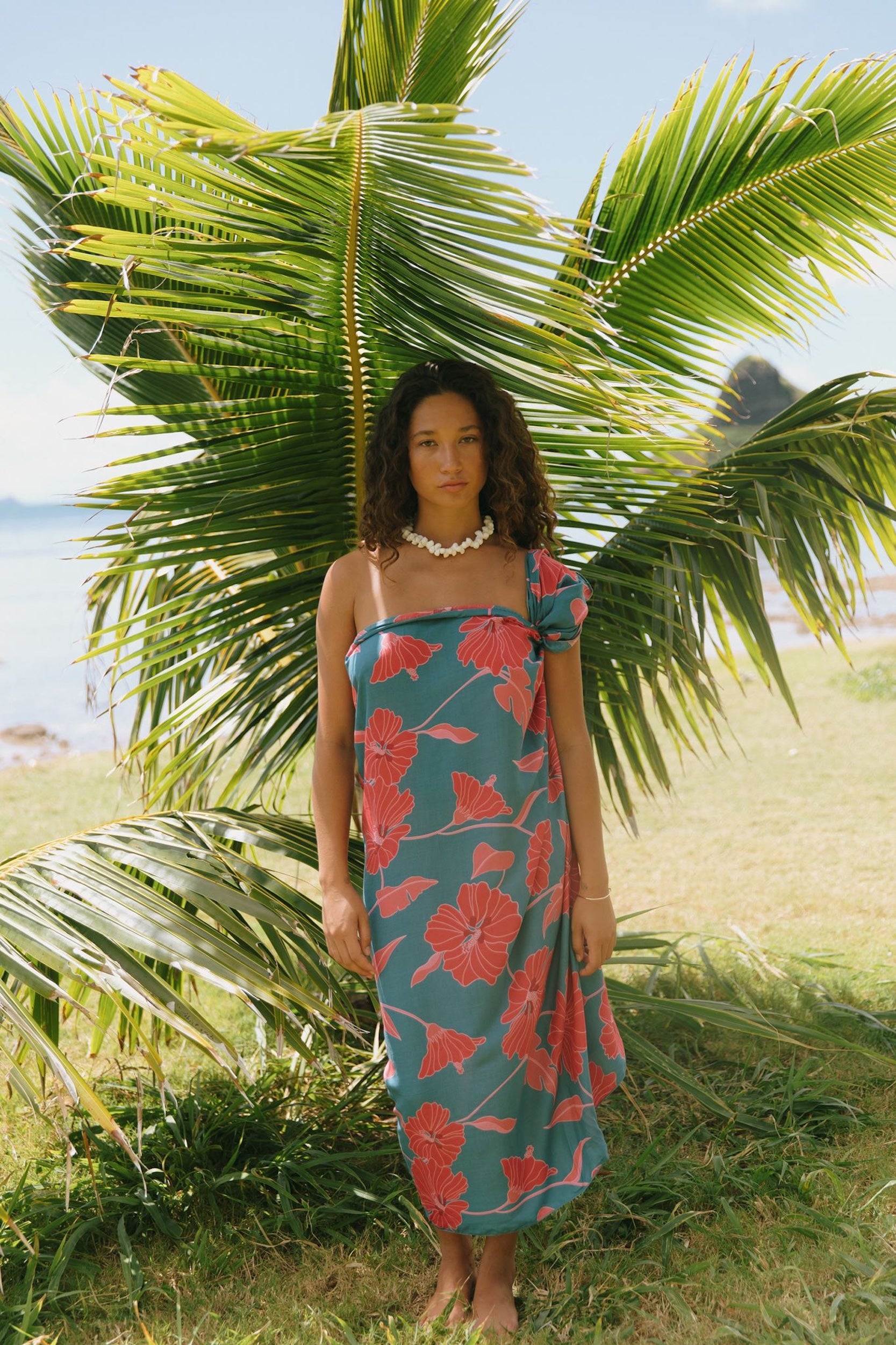 woman wearing rich teal pareo with red hau flower print