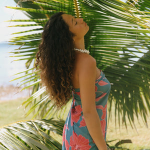 woman wearing rich teal pareo with red hau flower print