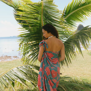 woman wearing rich teal pareo with red hau flower print