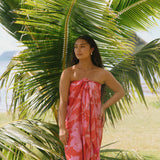 woman with brown hair wearing red pareo with pink hau flower print