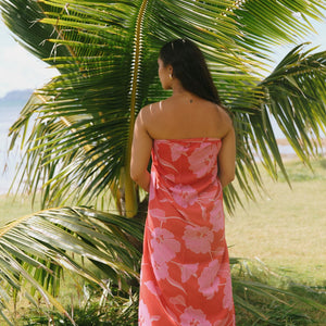 woman with brown hair wearing red pareo with pink hau flower print