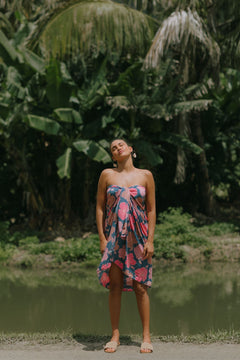 woman with brown hair wearing blue and pink pareo with hibiscus print