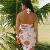 woman with brown hair wearing light white pinkish pareo with large red hibiscus print
