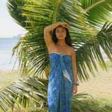 woman with brown hair wearing teal aqua pareo with blue solid hibiscus print