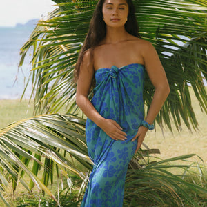 woman with brown hair wearing teal aqua pareo with blue solid hibiscus print
