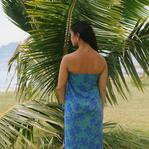 woman with brown hair wearing teal aqua pareo with blue solid hibiscus print