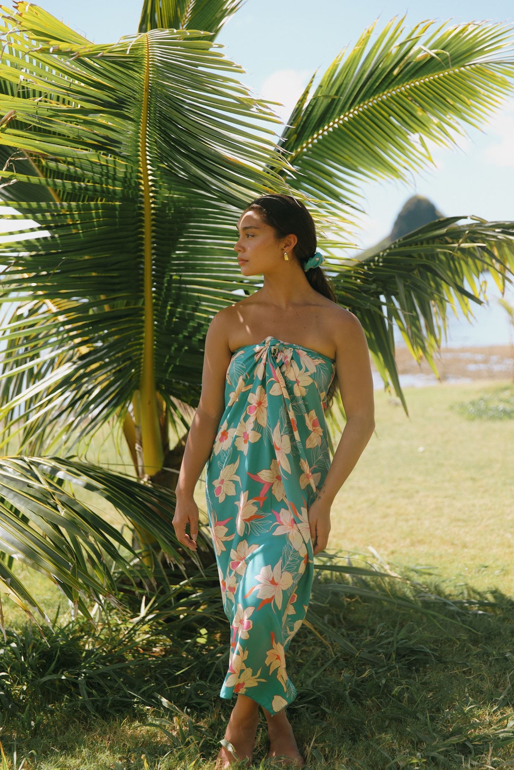 woman with brown hair wearing teal pareo with orchid print
