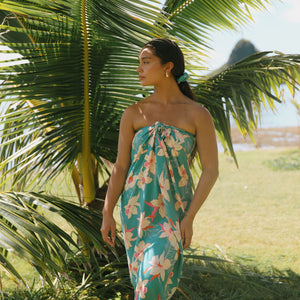 woman with brown hair wearing teal pareo with orchid print