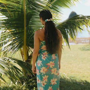 woman with brown hair wearing teal pareo with orchid print