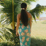 woman with brown hair wearing teal pareo with orchid print