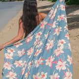 woman wearing a teal pareo with cream colored orchid pattern