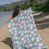 woman wearing a teal pareo with cream colored orchid pattern