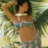 woman with brown hair wearing teal pareo with pink hibiscus print