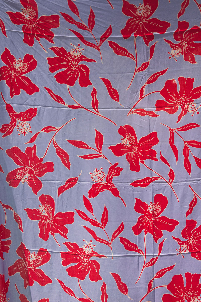 a pareo with periwinkle background and bright red hibiscus print.