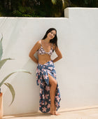 woman with black hair wearing a pareo in a navy and pink hibiscus print. 