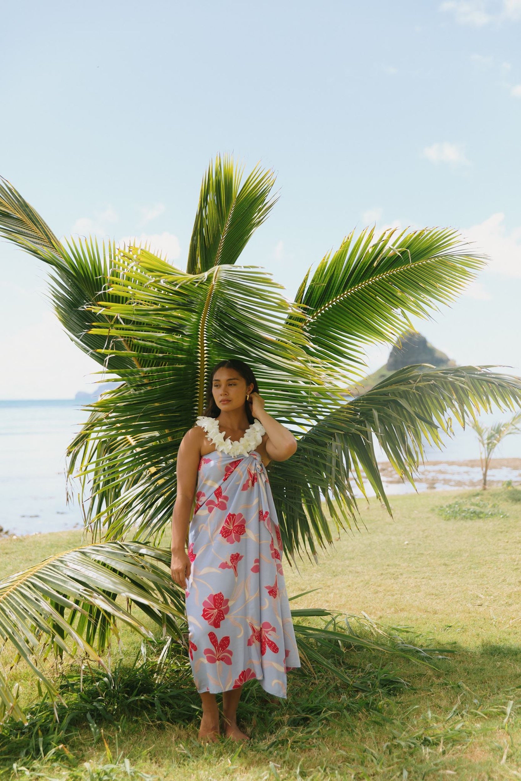 woman with brown hair wearing light lavender hibiscus pareo