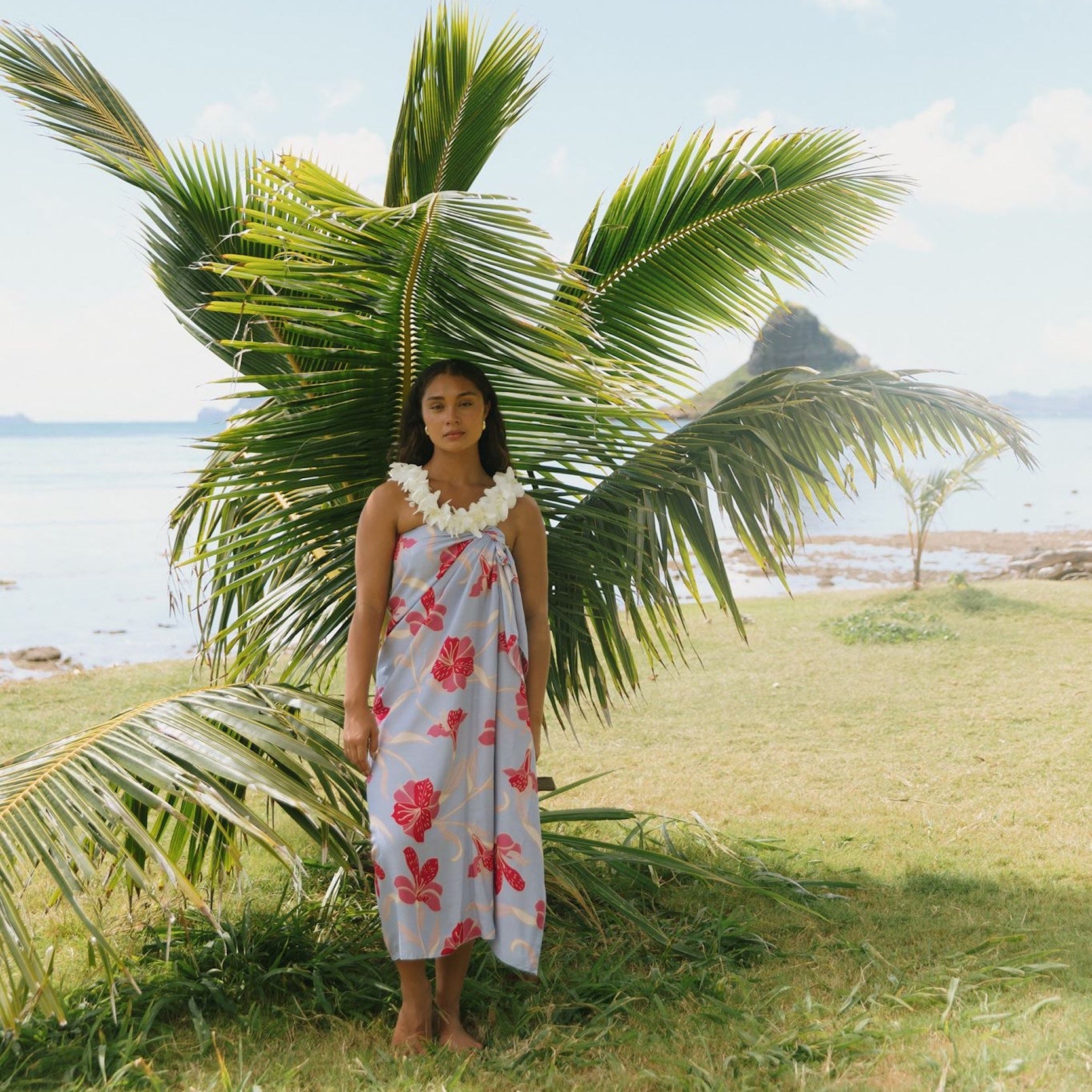 woman with brown hair wearing light lavender hibiscus pareo