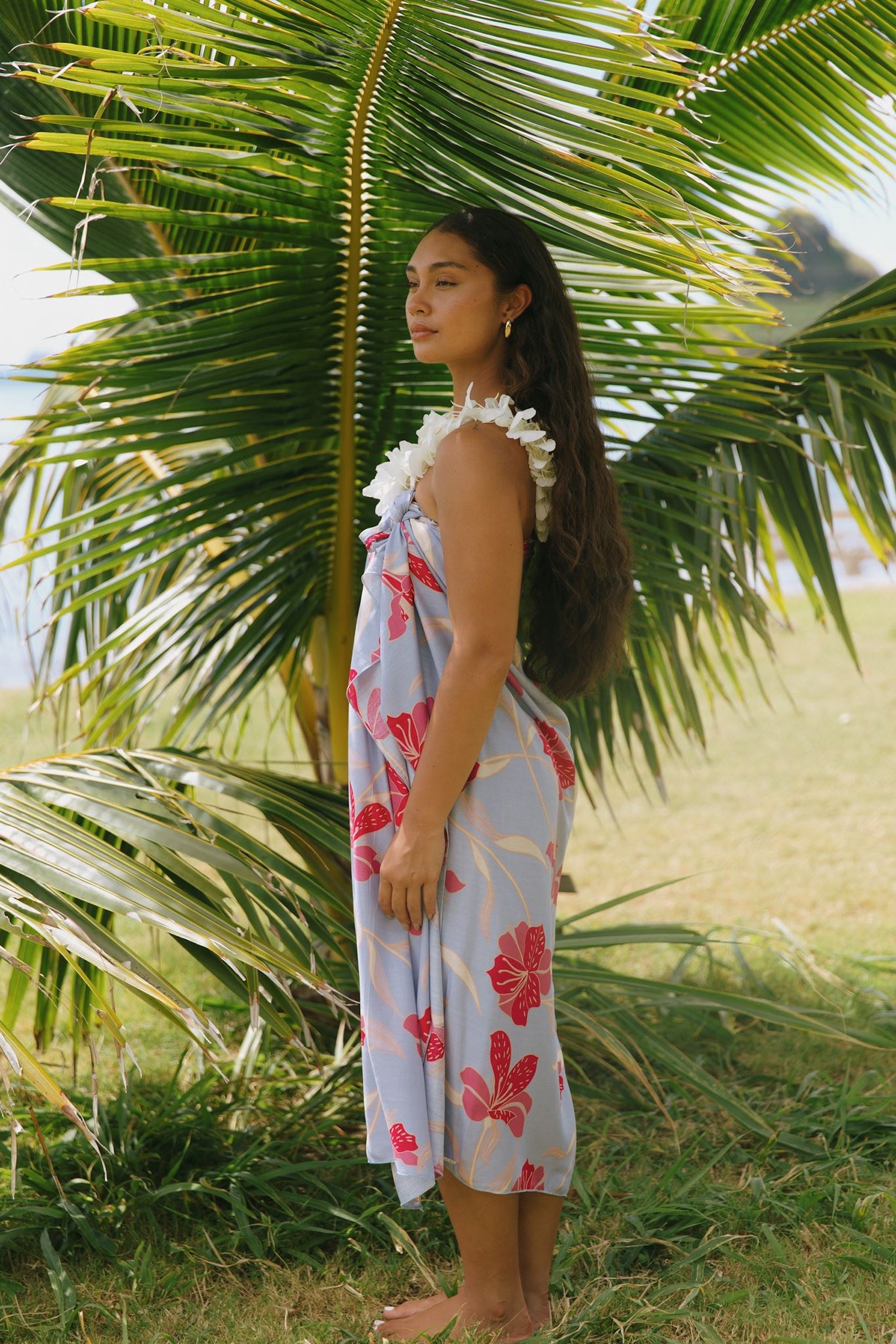 woman with brown hair wearing light lavender hibiscus pareo